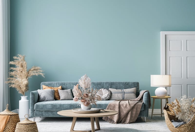 Mint green interior wall with long velvet sofa