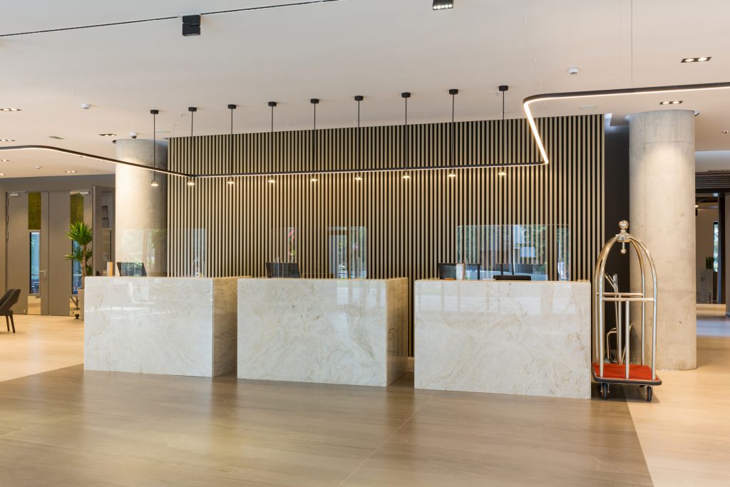 Interior Commercial Painters Interior of a hotel lobby with reception desks with transparent coronavirus plexiglass lexan clear sneeze guards